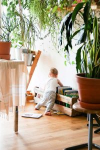 baby searching a book - gross motor skills the right environment